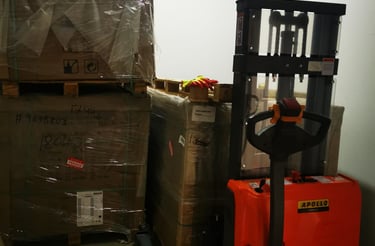 Stacks of packaged boxes and a forklift in a warehouse, representing logistics and shipping.
