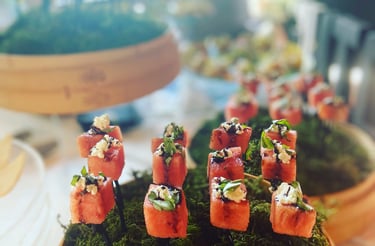 a table with a basket of sushiki and sushi canapes, displayed for a corporate happy hour event