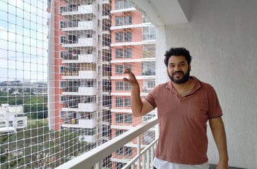 Technician carefully installing a sturdy pigeon net on a balcony in Richmond Town.