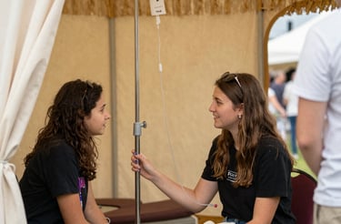 A friendly nurse setting up an IV drip inside a cozy festival camper.