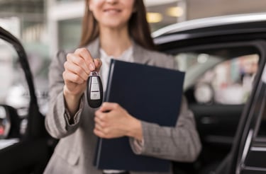 Expat holding car keys and documents for vehicle registration process in Spain with insurance