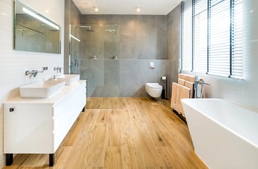 Nowoczesna łazienka z wanną, prysznicem, dwiema umywalkami i drewnianą podłogą