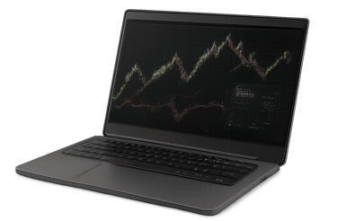 A dark gray laptop showing a complex stock trading chart with green and red lines and a small overlay showing additional trade information.
