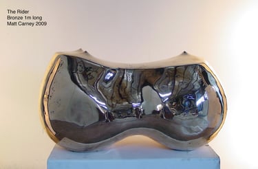 a polished bronze reflective sculpture of curved abstract form