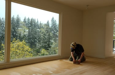 a craftsman trowel filling a hardwood floor with wood grain filler