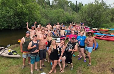 a group of people standing around a group of kayaks