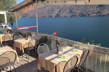 Una terrazza sul lago di Lugano del ristorante Roccabella con tavoli e sedie