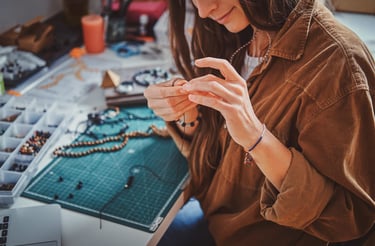 Mujer artesana armando joyería para utilizar en taller de macramé