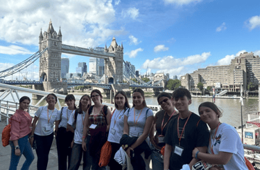 Un grupo de estudiantes de Priegoenglish por Londres, con el Tower Bridge al fondo.