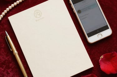 Elegant red and gold invitation card with a pen on a velvet surface.