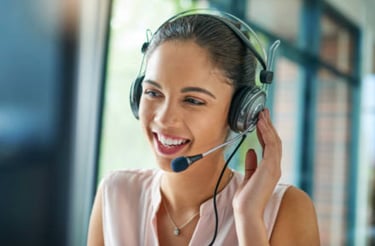 a woman in a pink shirt and headphones with a headset