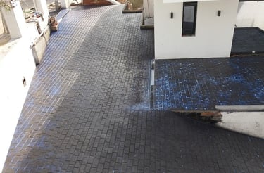 Superficie de hormigón impreso en color pizarra con diseño de adoquines, ideal para entradas y caminos residenciales modernos