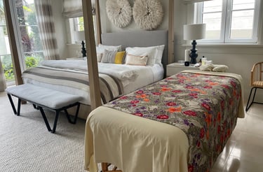 a bed with a canopy bed and a bench and a massages by sophia table