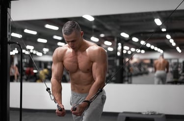 Muscular man performing a cable chest fly workout in a modern gym for strength training.