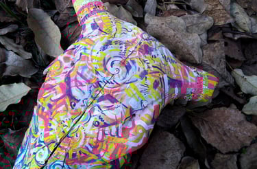 peinture aux couleurs vives sur un crane  sur un lit de feuilles mortes