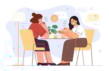 Dos mujeres sentadas a una mesa y se miran y se hablan