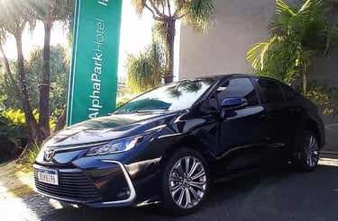 a black car parked in front of a sign