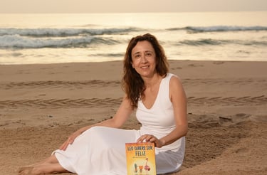 Foto de la autora de Leo wants to be happy con el primer libro de Leo en la playa