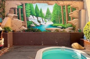 mural de un bosque con unas cascadas en la pared de un jardín particular