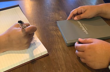 a person holding a book and a notebook