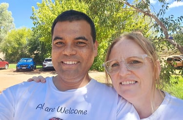 a man and woman standing in front of a tree