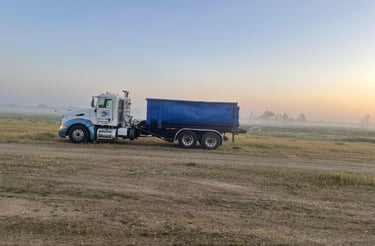 a truck with a blue dumpster on the side