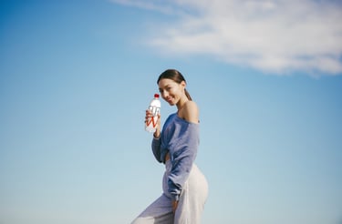 agua alcalina: mujer sosteniendo una botella