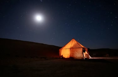 lluminated desert tent under full moon in the Sahara night sky