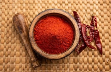 a bowl of chili powder with chili peppers and spices