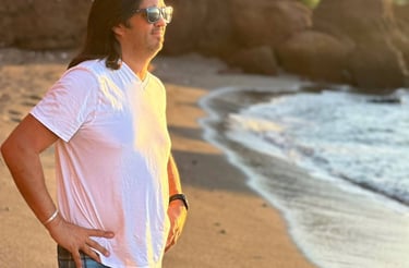 a man standing on a beach with a surfboard