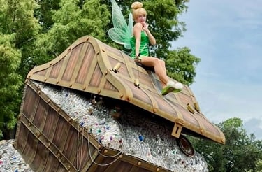 Tinkerbell sitting on top a treasure chest during a parade