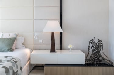 Modern bedside table with lamp and sculpture at Villa Serenity