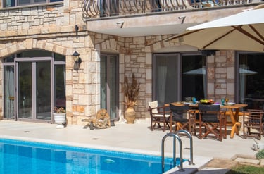 a pool by the villa and pool deck with a gathering and dining area