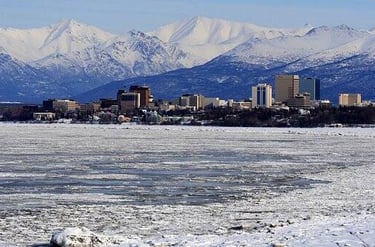 Anchorage, AK - A view of the city of Anchorage in winter with mountains in the background