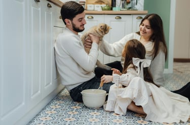 family relaxing together on the sofa in a bright, tidy living room with soft light