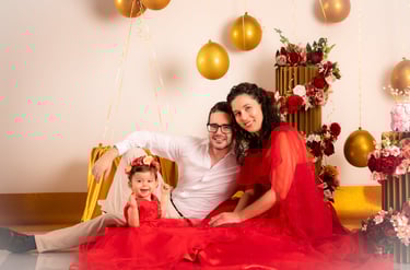 a man and woman sitting on a chair with balloons