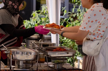 Gäste erhalten frisch serviertes indonesisches Essen auf einem Streetfood Markt