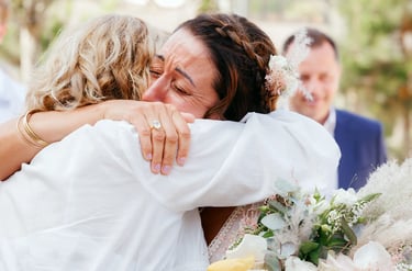 Photographie de mariée qui pleure de bonheur en serrant dans ses bras sa mère après la cérémonie de mariage, Talmont, Vendée