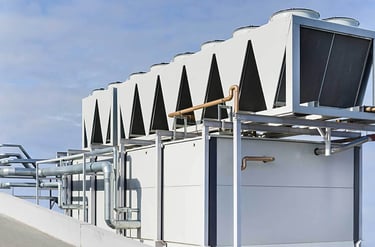 Industrial rooftop HVAC system with air-cooled condensers and water piping.
