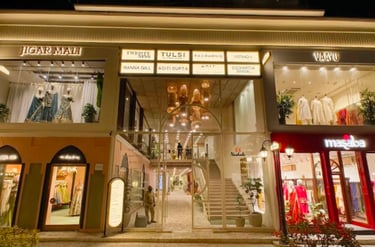 Luxury fashion boutiques including Masaba and Jigar Mali at a high-end designer retail mall at night.