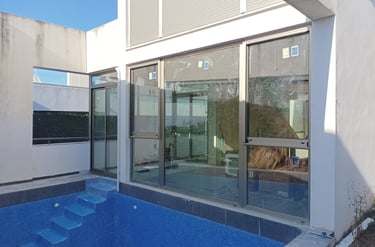 Carpintería de aluminio color Inox. ante piscina descubierta.
