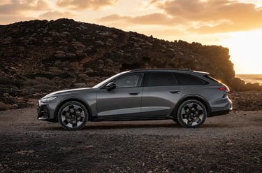 Audi A6 Allroad em perfil lateral durante o pôr do sol com cenário off-road ao fundo