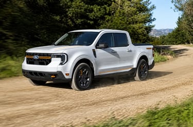 Ford Maverick trafegando em estrada de terra cercada por árvores e vegetação