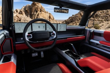 Interior do GMC Hummer X com telas digitais e vista para trilha no deserto