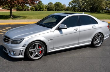 Mercedes C63 AMG prata estacionada com rodas esportivas e visual agressivo