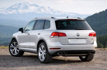Volkswagen Touareg V6 2015 prata traseira lateral com motor 280 cv em cenário de montanha
