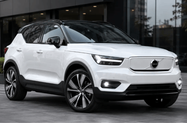 Volvo XC40 Recharge branco estacionado em frente a showroom urbano moderno