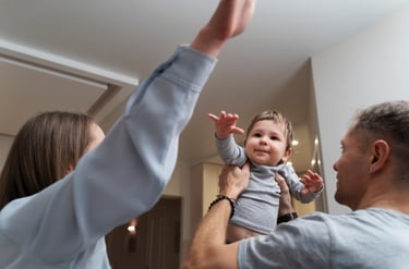 a man and woman holding a baby in a living room
