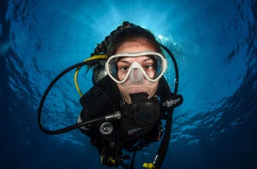 a woman in a scuba suit and goggles in the water