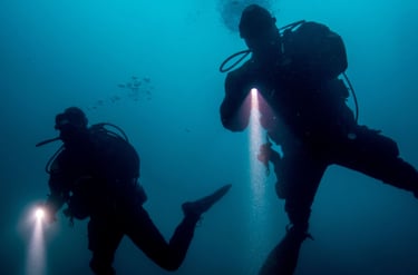 two divers in the water with a flashlight